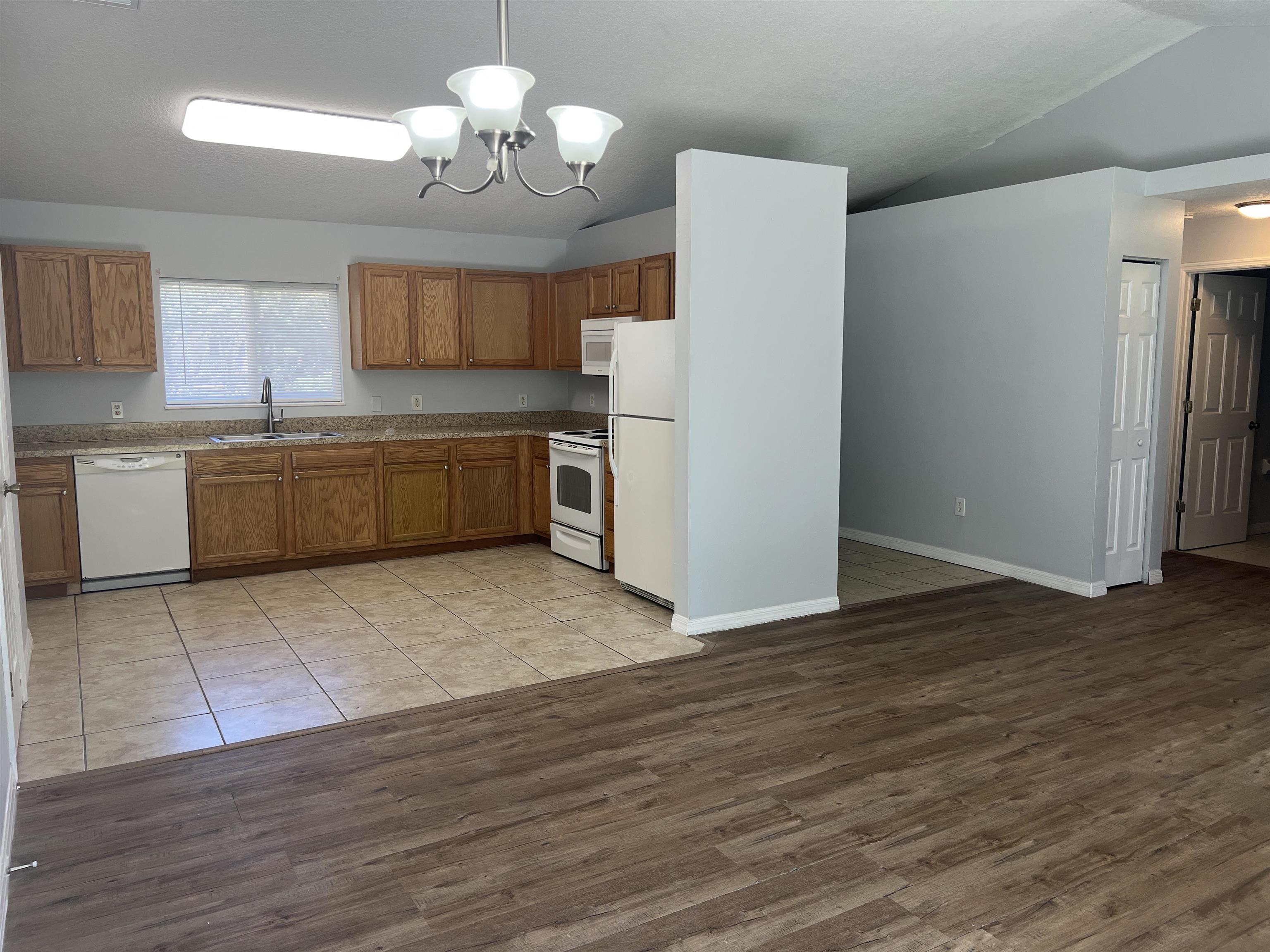 5465 Datil Pepper Road St. Augustine, FL 32086 - Photo 6 of 28 a kitchen with a refrigerator a sink dishwasher a kitchen island with wooden floor