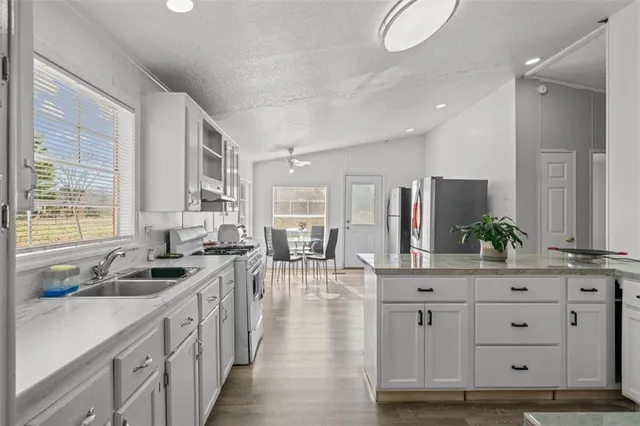 a kitchen with white cabinets and sink