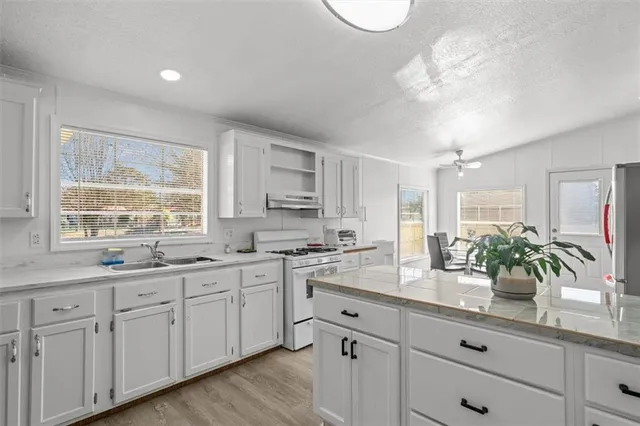 a kitchen with white cabinets and chandelier
