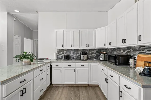 a kitchen with granite countertop white cabinets white appliances and sink