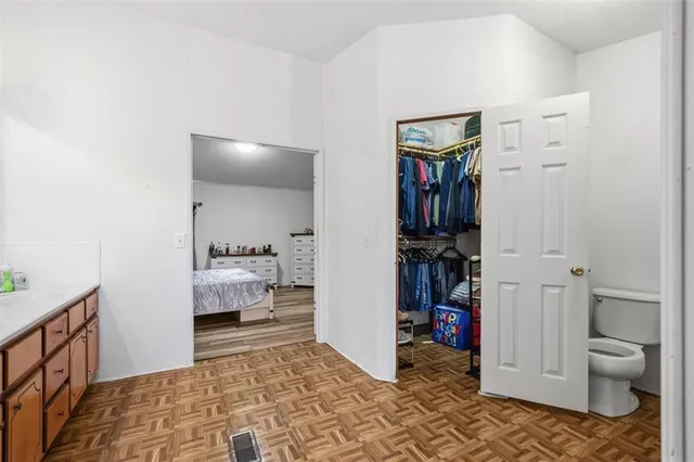 a view of a hallway with walk in closet and bedroom