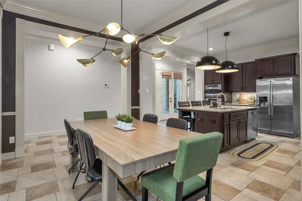 a kitchen with a dining table chairs sink refrigerator and microwave