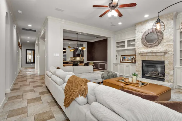 a living room with furniture a fireplace and a chandelier
