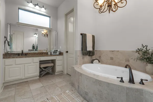 a bathroom with a tub sink and mirror