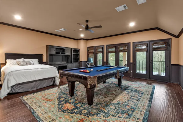 a bedroom with a bed table and flat screen tv