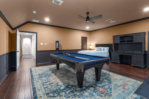 a room with pool table a projector and a bookshelf