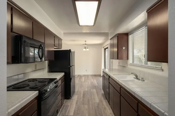 a kitchen with stainless steel appliances granite countertop a stove a sink and a refrigerator