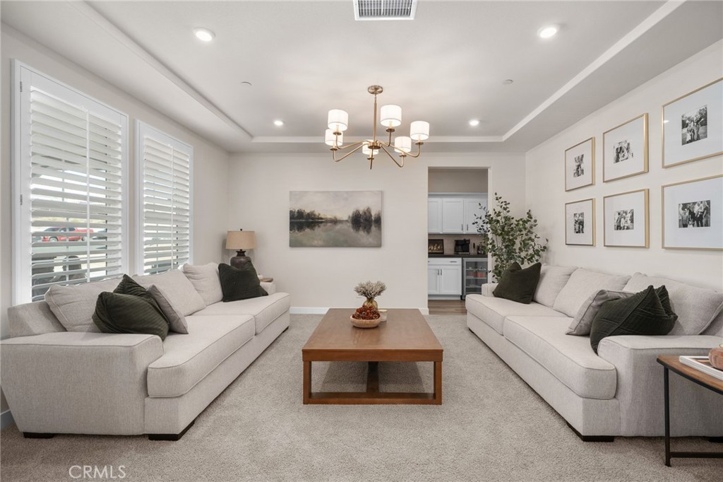 16155 New Canaan Court Riverside, CA 92504 - Photo 4 of 26 a living room with furniture a chandelier and a large mirror