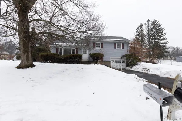 a front view of house with yard covered in snow