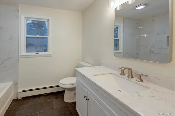 a bathroom with a sink toilet and a mirror