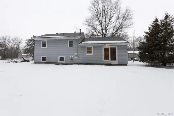 a front view of house with yard and trees in the background