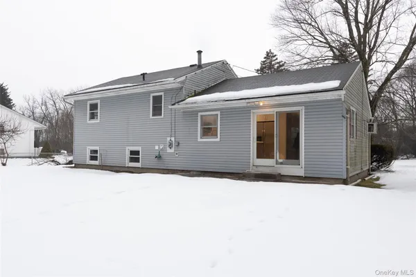 a front view of house with yard covered in snow