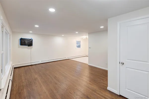 a view of an empty room with wooden floor