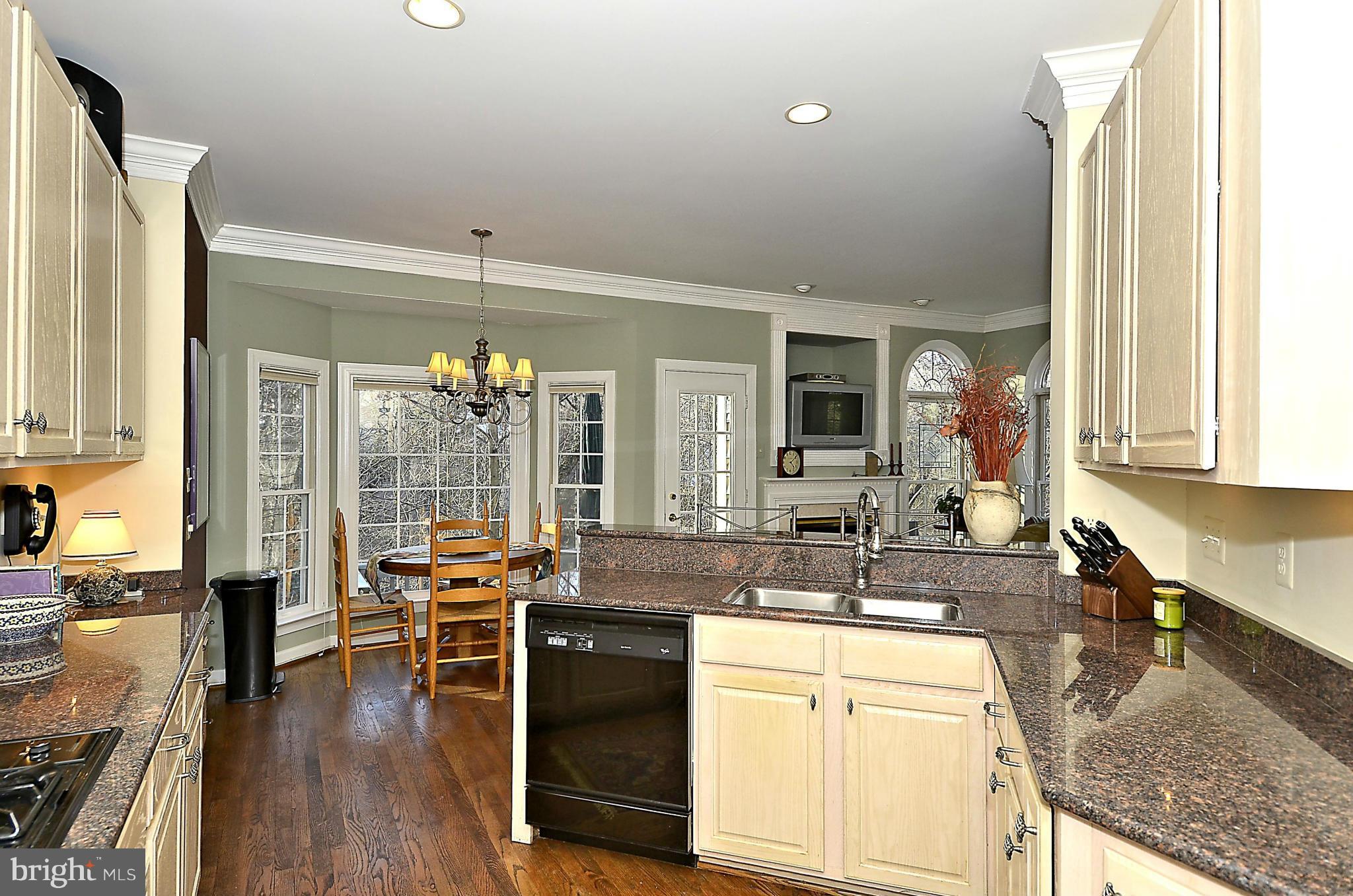 148 Rees Place Falls Church, VA 22046 - Photo 14 of 29 a large kitchen with granite countertop a large window and white cabinets