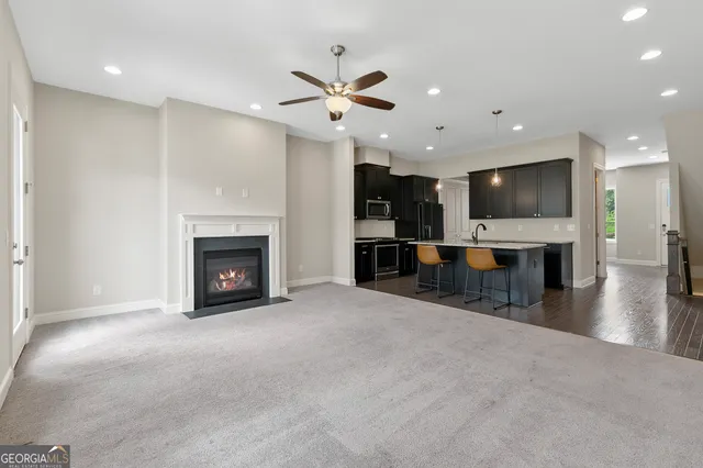 a view of a livingroom with fireplace and a kitchen