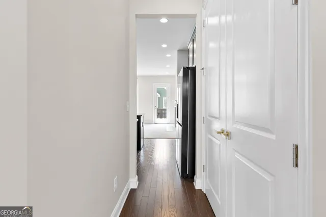 a view of a hallway with wooden floor and staircase
