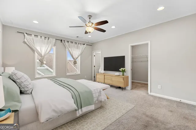 a bedroom with a bed window and a flat screen tv