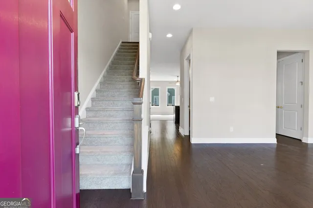 a view of a hallway with wooden floor and staircase