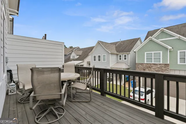 a view of a house with wooden deck and furniture
