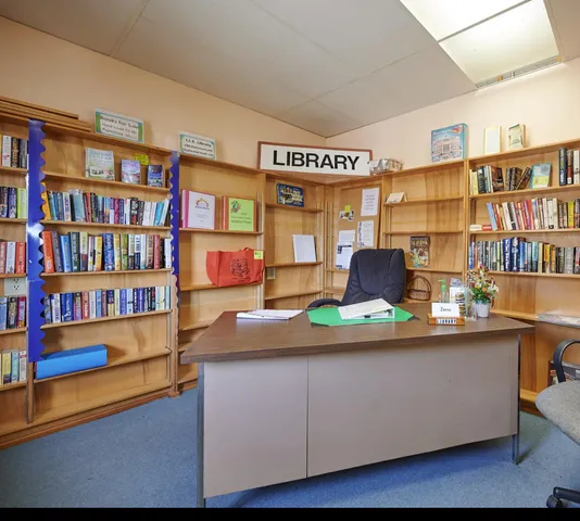 a room with lots of books and wooden cabinets