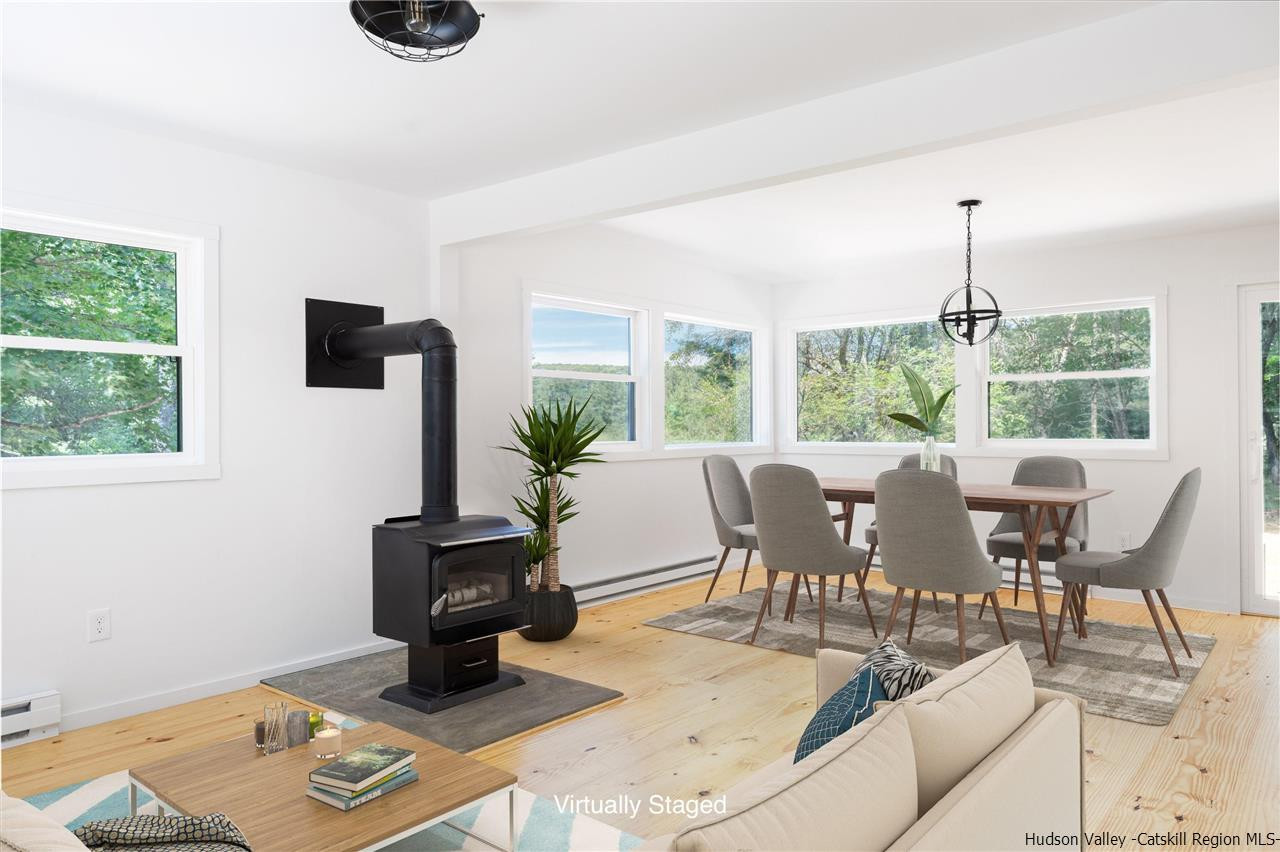 5646 Red Hill Road Claryville, NY 12725 - Photo 6 of 35 a dining room with furniture a rug a potted plant and a large window