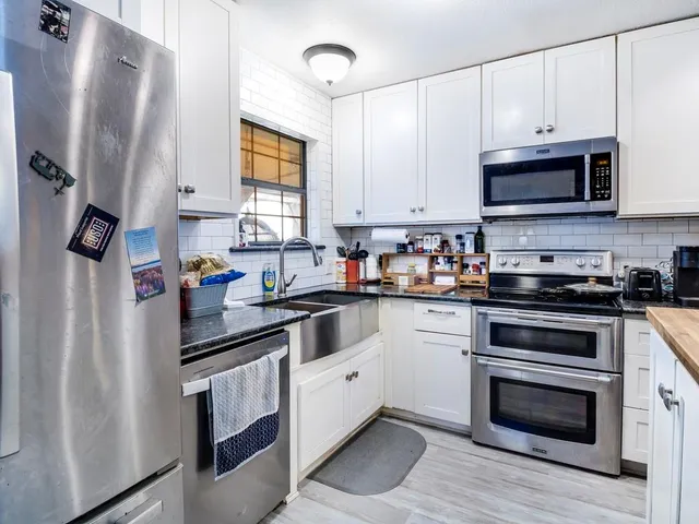 a kitchen with stainless steel appliances granite countertop a refrigerator sink and microwave