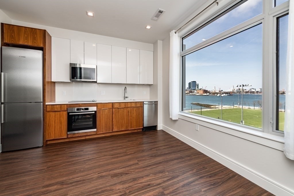a kitchen with a stove a refrigerator and a wooden floor