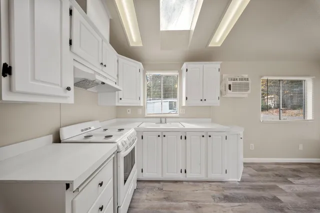 a kitchen with cabinets appliances a sink and a window