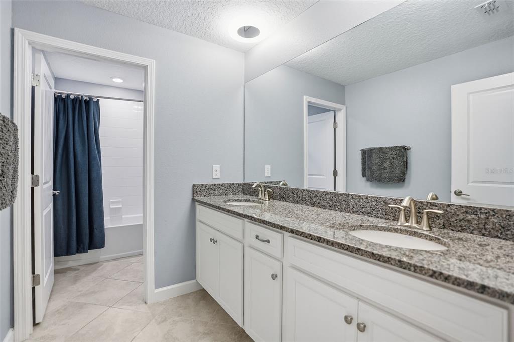 8676 Capstone Ranch Drive New Port Richey, FL 34655 - Photo 30 of 47 a bathroom with a granite countertop sink double and mirror