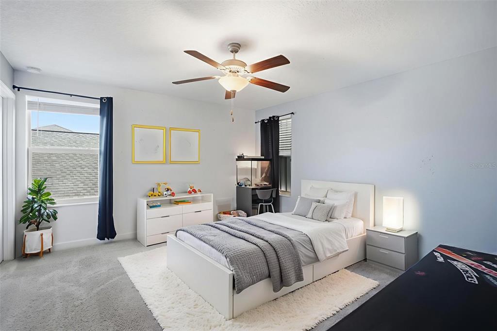 8676 Capstone Ranch Drive New Port Richey, FL 34655 - Photo 33 of 47 a bedroom with a bed and a chandelier