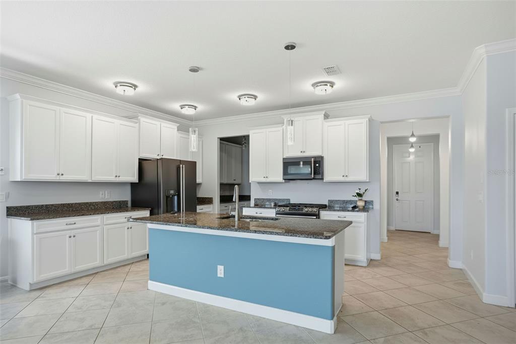 8676 Capstone Ranch Drive New Port Richey, FL 34655 - Photo 7 of 47 a kitchen with stainless steel appliances granite countertop a sink stove and refrigerator