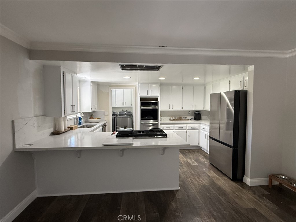 1530 Robin Way Fullerton, CA 92835 - Photo 19 of 35 a large kitchen with stainless steel appliances a large counter top a stove and a refrigerator