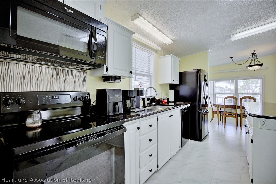 2702 Rodney Street Sebring, FL 33872 - Photo 10 of 33 a kitchen with stainless steel appliances kitchen island granite countertop a refrigerator stove and sink