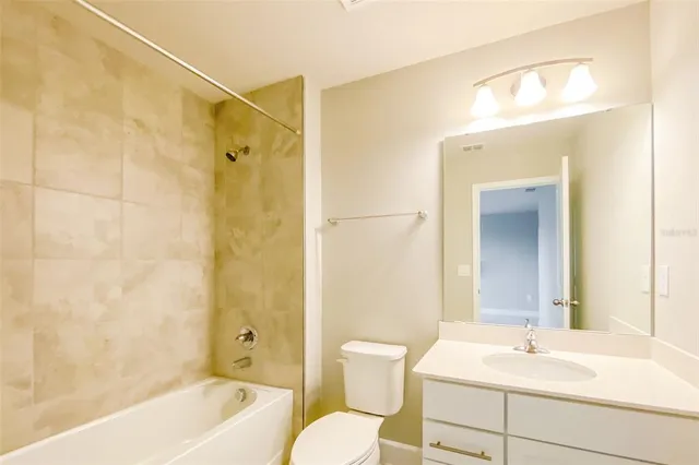 a spacious bathroom with a tub sink and mirror