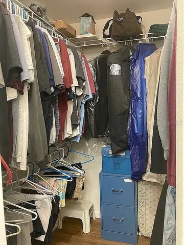 a view of walk in closet with clothes and shoes