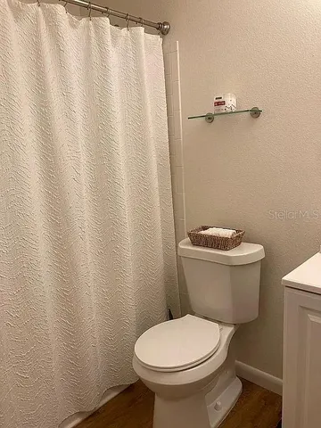 a white toilet sitting next to a shower curtain