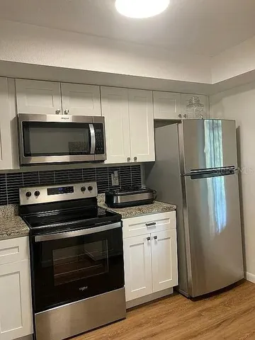 a kitchen with a refrigerator stove and microwave