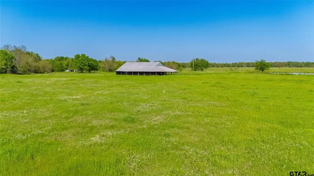 a backyard of a house with lots of green space and lake view