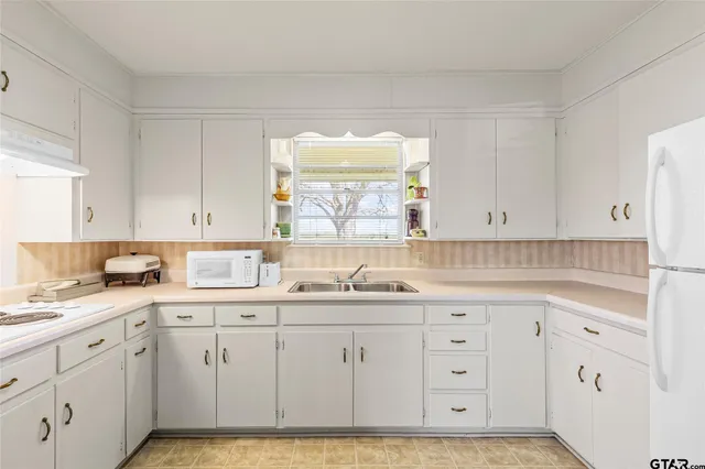 a kitchen with white cabinets sink and white appliances