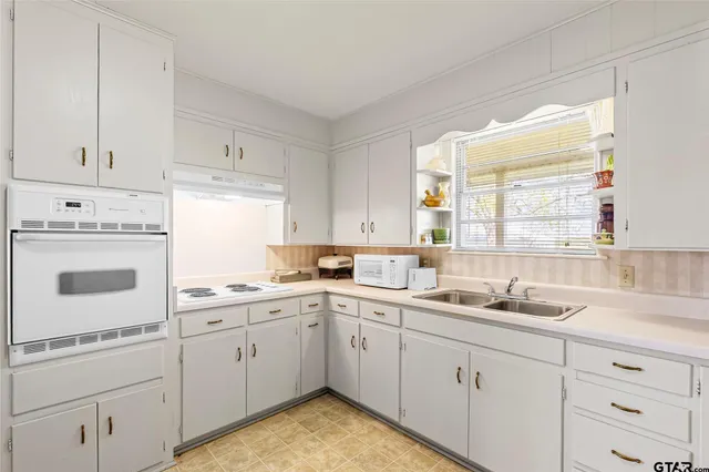 a large white kitchen with cabinets