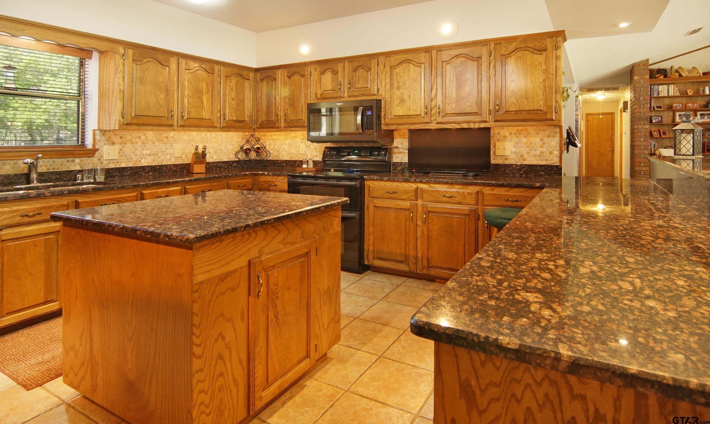 227 Private Road 5885 Yantis, TX 75497 - Photo 38 of 41 a kitchen with stainless steel appliances granite countertop a sink stove and refrigerator