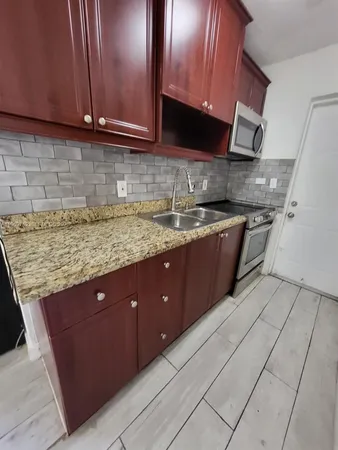 a kitchen with stainless steel appliances granite countertop wooden cabinets a sink and dishwasher