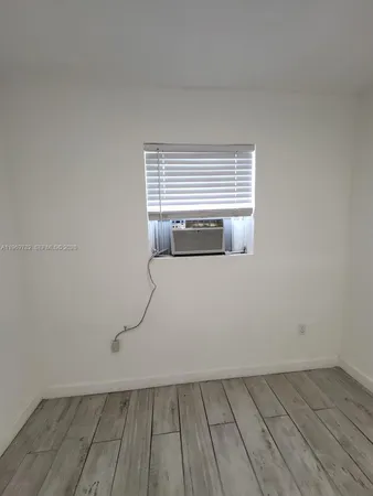 a room with a wooden floor and white walls