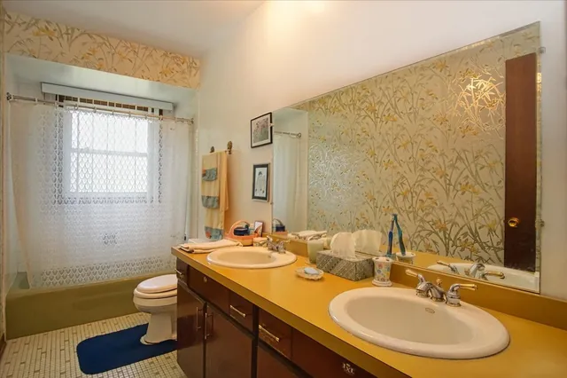a bathroom with a granite countertop sink toilet a mirror and shower