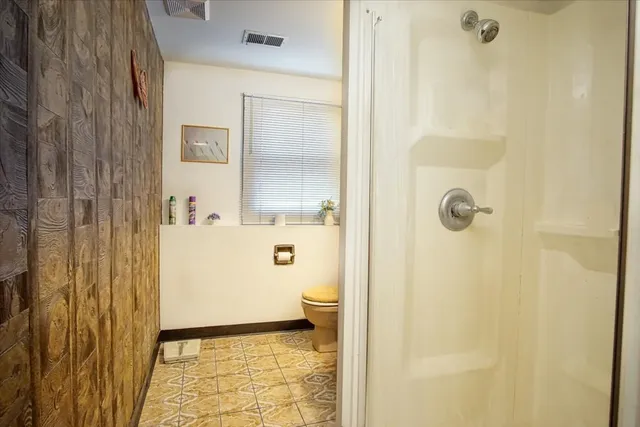 a bathroom with a granite countertop sink a toilet and shower
