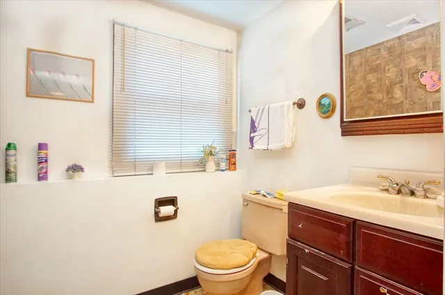 a bathroom with a sink a toilet and a window