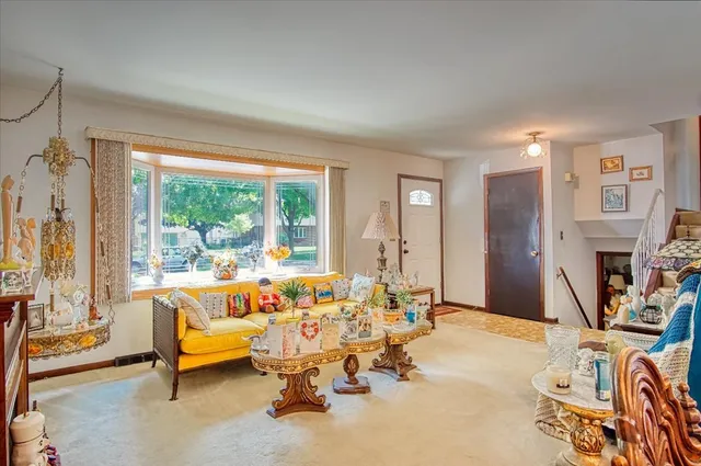 a living room with furniture a fireplace and a floor to ceiling window
