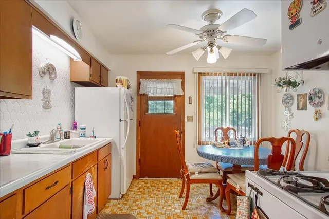 a kitchen with stainless steel appliances granite countertop a stove a sink dishwasher and a dining table with wooden floor