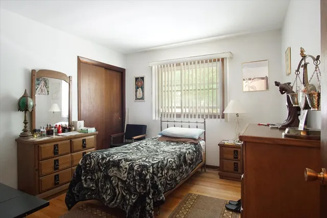 a bedroom with a bed and a dresser next to a window