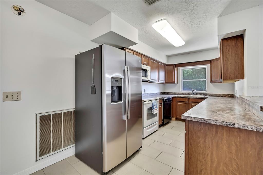 12130 Maple Street Dunnellon, FL 34432 - Photo 11 of 54 a kitchen with stainless steel appliances granite countertop a refrigerator a sink a stove a microwave and island